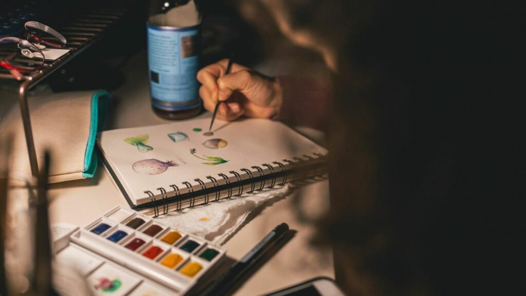 person painting on spiral book